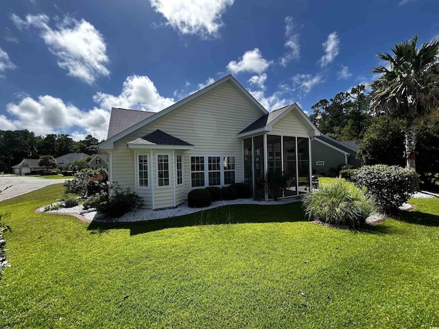 back of property with a yard and a sunroom