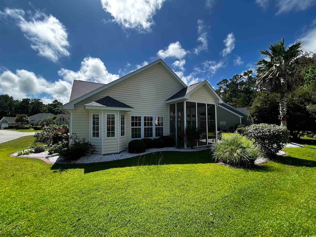 back of house with a yard and a sunroom