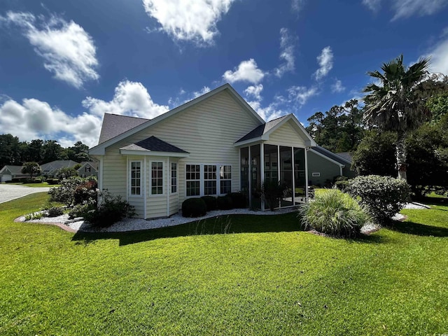 back of property with a sunroom and a yard