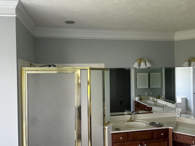 full bath featuring a stall shower, ornamental molding, a textured ceiling, and vanity