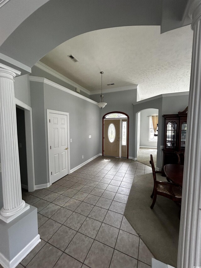 tiled entryway with arched walkways, visible vents, decorative columns, and crown molding