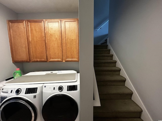 laundry room with washing machine and clothes dryer and cabinet space