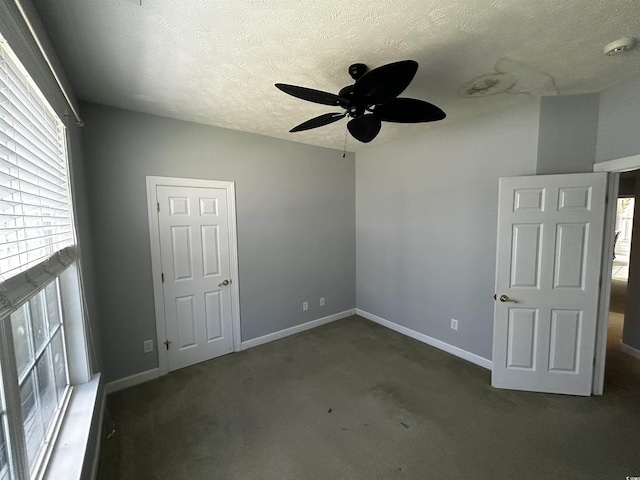 spare room featuring a ceiling fan, carpet, a textured ceiling, and baseboards