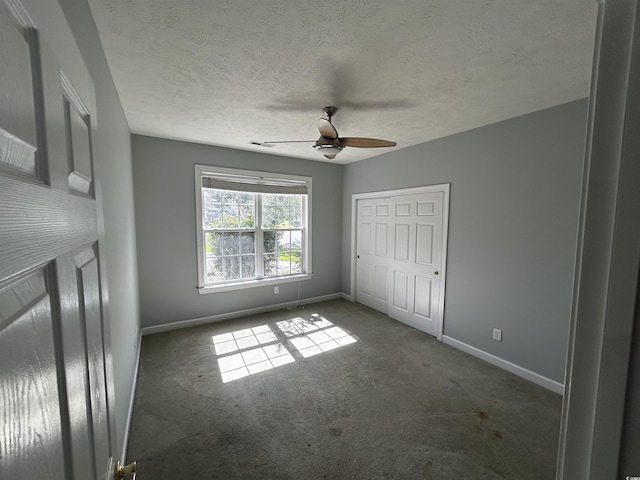 unfurnished bedroom with carpet floors, a closet, a textured ceiling, and baseboards