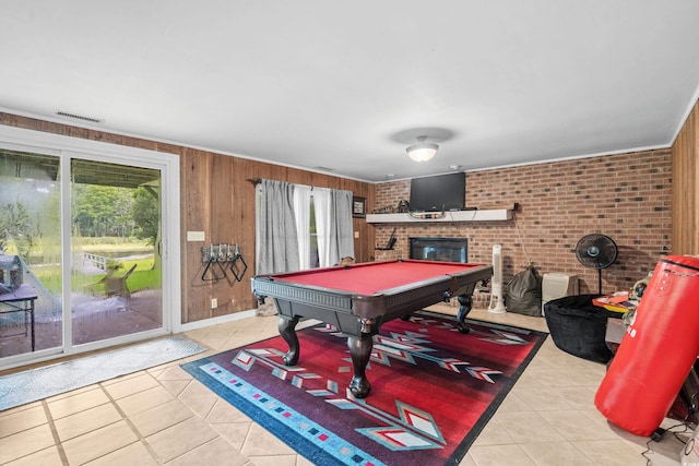 playroom featuring light tile patterned flooring, brick wall, wooden walls, a fireplace, and billiards