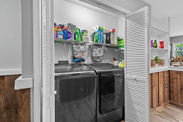 laundry room with washer and dryer and light wood-type flooring