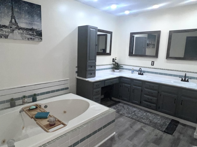 bathroom with vanity, hardwood / wood-style flooring, tiled bath, and decorative backsplash