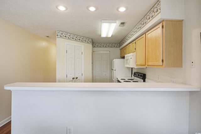 kitchen featuring dark hardwood / wood-style floors, white appliances, kitchen peninsula, and light brown cabinetry