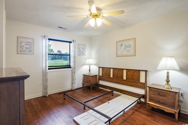 living area featuring ceiling fan, dark hardwood / wood-style flooring, and a textured ceiling