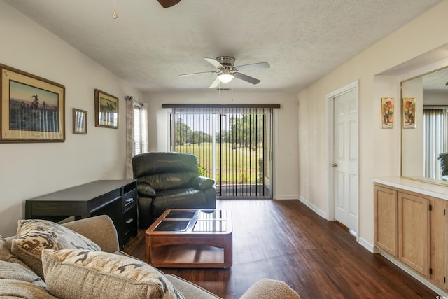 living room featuring ceiling fan, dark hardwood / wood-style flooring, and a textured ceiling