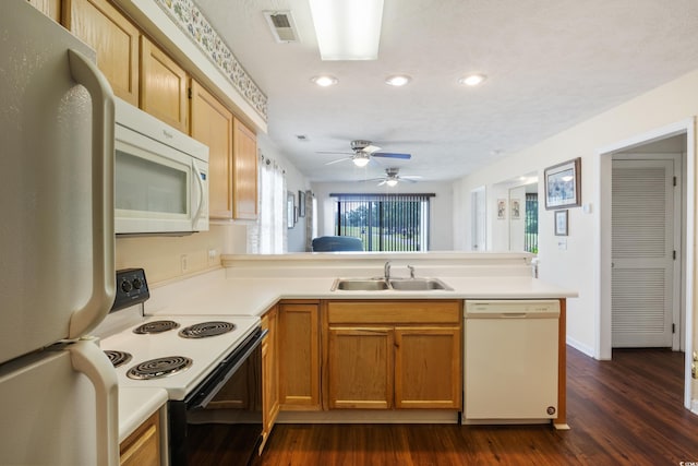 kitchen featuring white appliances, sink, ceiling fan, dark hardwood / wood-style flooring, and kitchen peninsula