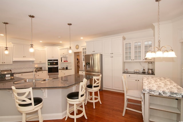 kitchen with decorative backsplash, dark hardwood / wood-style floors, sink, white cabinets, and a center island