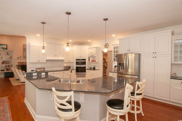 kitchen featuring sink, appliances with stainless steel finishes, dark wood-type flooring, white cabinetry, and pendant lighting