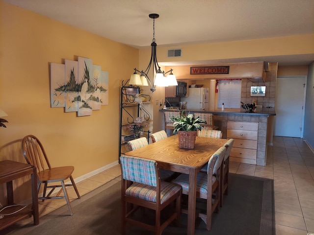 tiled dining area with an inviting chandelier