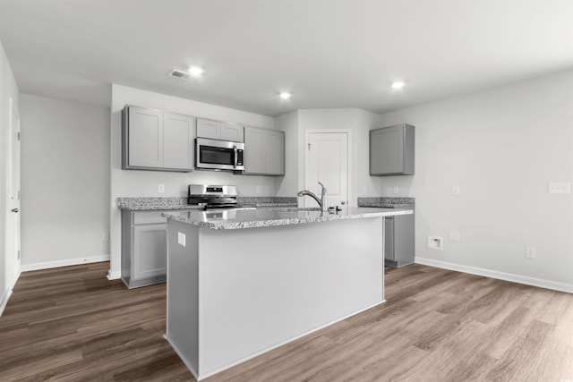 kitchen featuring stainless steel appliances, wood finished floors, and gray cabinetry