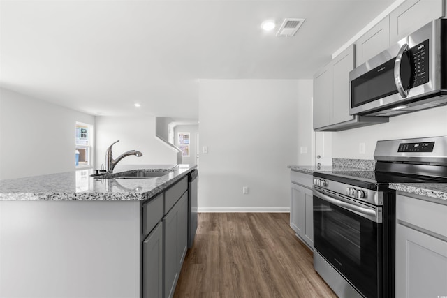 kitchen featuring dark wood-style floors, visible vents, gray cabinetry, appliances with stainless steel finishes, and a sink