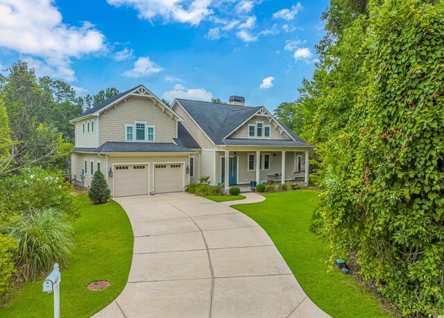 view of front of house with a front yard, covered porch, and a garage