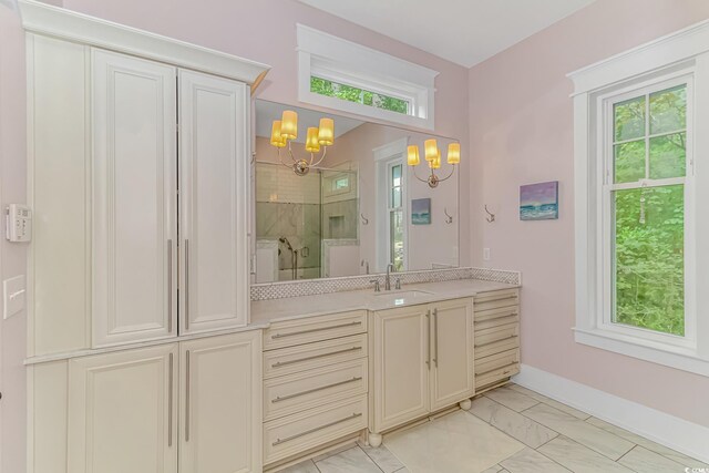 bathroom featuring tile patterned floors, vanity, tiled shower, and an inviting chandelier