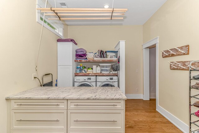 interior space featuring washer and dryer, light hardwood / wood-style flooring, and light stone counters