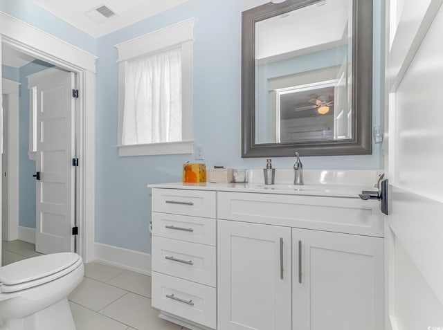 bathroom with toilet, vanity, and tile patterned flooring