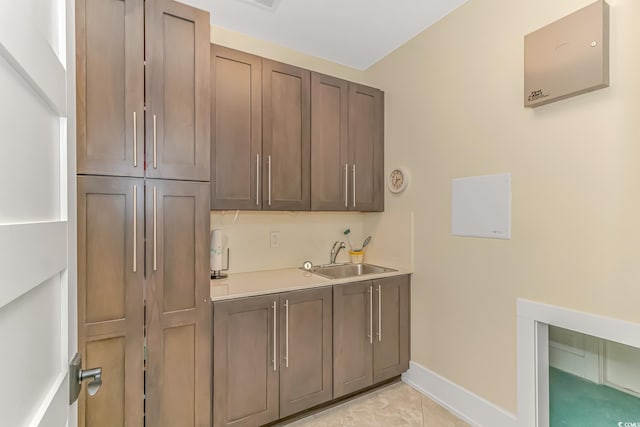 laundry room with light tile patterned floors and sink