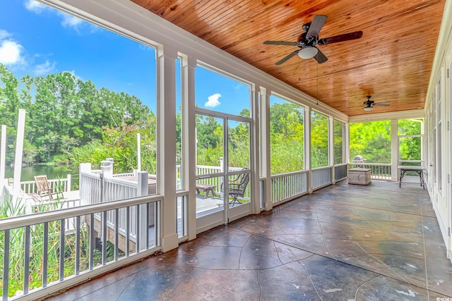 unfurnished sunroom with ceiling fan, wood ceiling, and a healthy amount of sunlight