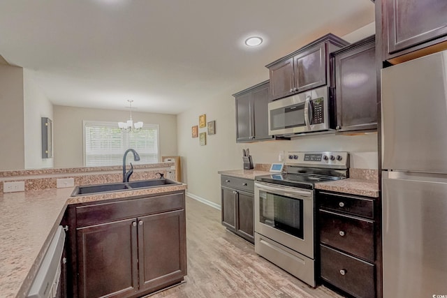 kitchen with a healthy amount of sunlight, dark brown cabinetry, a chandelier, and sink