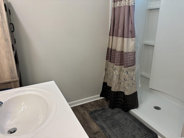 bathroom with a shower with shower curtain, wood-type flooring, and sink