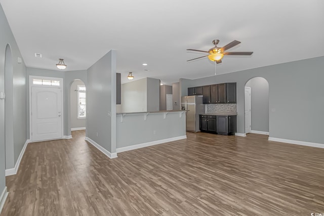 unfurnished living room featuring ceiling fan and hardwood / wood-style floors