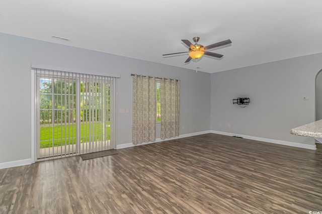 empty room with ceiling fan and dark wood-type flooring