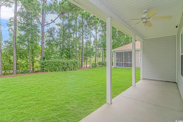 view of yard featuring ceiling fan, a patio area, and a sunroom