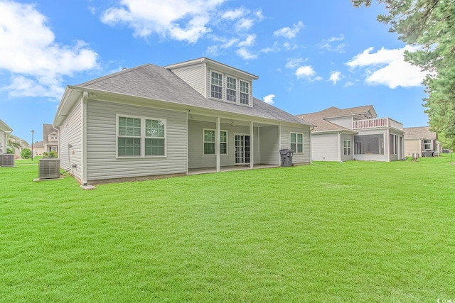 back of property with central AC unit, a yard, and a balcony