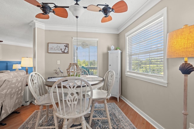 dining area featuring a textured ceiling, plenty of natural light, wood finished floors, and a ceiling fan