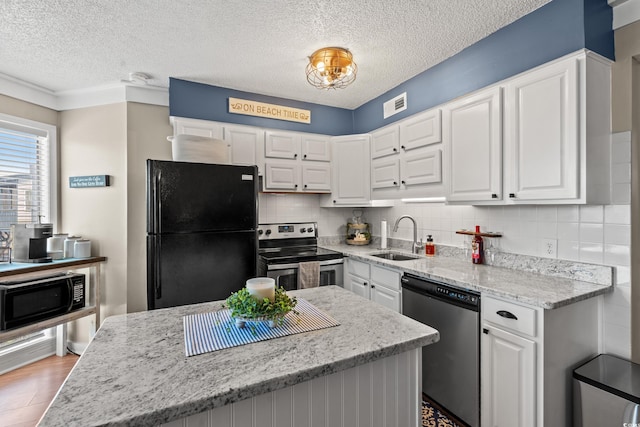 kitchen with black appliances, a sink, visible vents, and white cabinetry