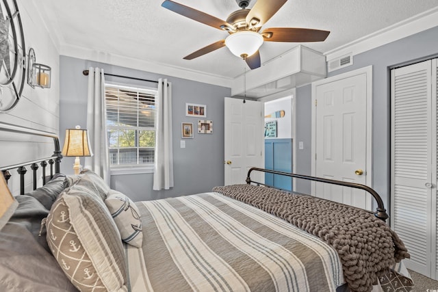 bedroom with a textured ceiling, ornamental molding, a closet, and visible vents