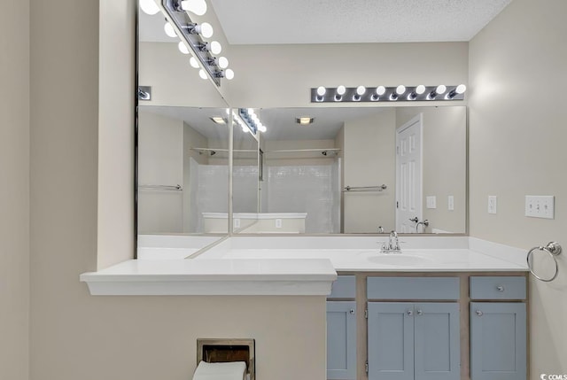 bathroom featuring vanity, a textured ceiling, and walk in shower