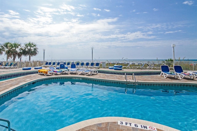 view of pool with a water view and a patio area