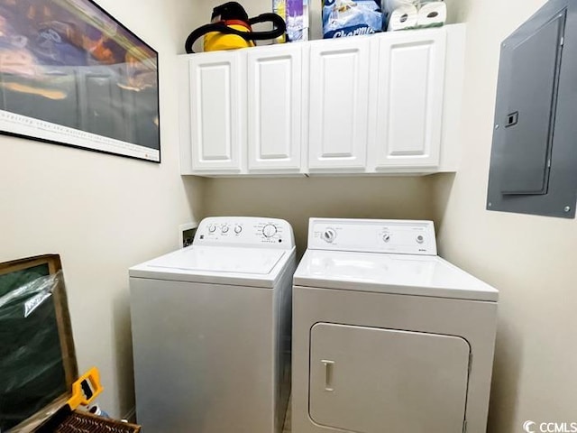 laundry area with washing machine and dryer, cabinets, and electric panel