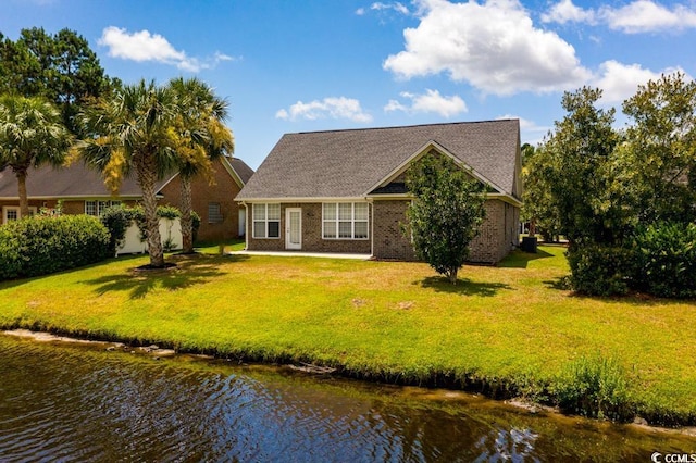 view of front of property featuring a water view and a front lawn