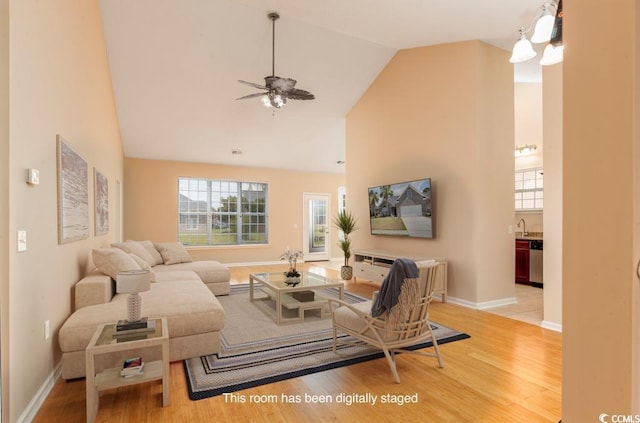 living room featuring hardwood / wood-style flooring, high vaulted ceiling, ceiling fan, and sink