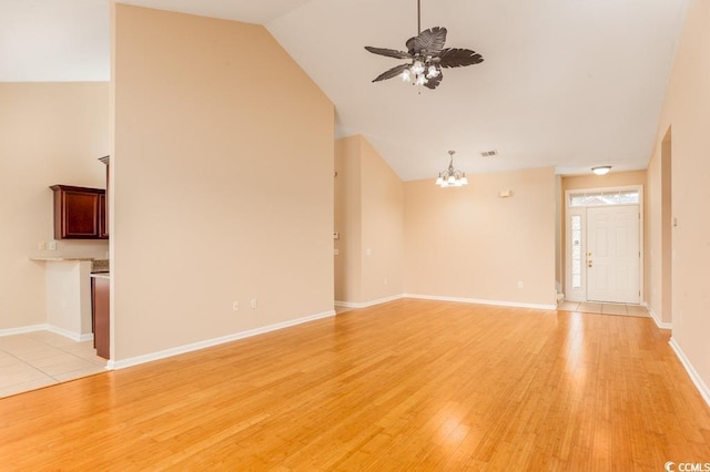 unfurnished living room featuring ceiling fan with notable chandelier, light hardwood / wood-style flooring, and lofted ceiling