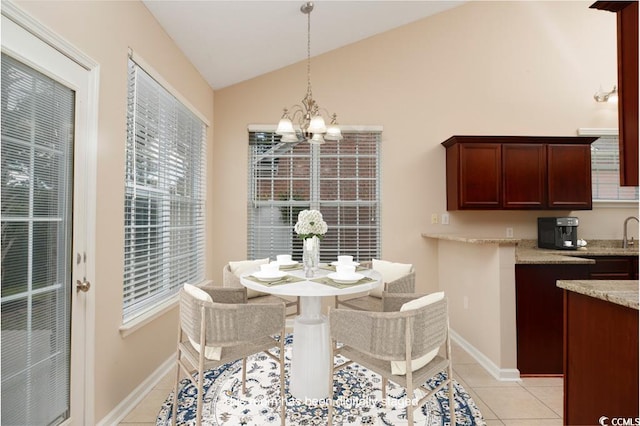 tiled dining room featuring lofted ceiling and a notable chandelier