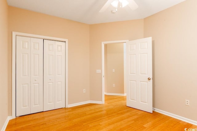 unfurnished bedroom featuring hardwood / wood-style flooring, ceiling fan, and a closet