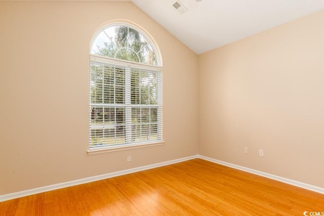 empty room featuring hardwood / wood-style flooring and vaulted ceiling