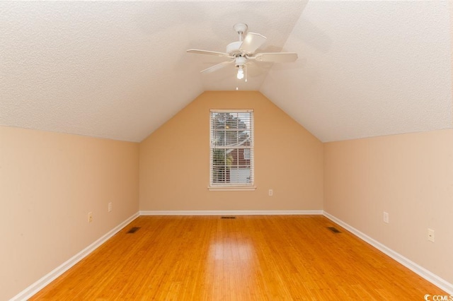 bonus room featuring hardwood / wood-style flooring, ceiling fan, a textured ceiling, and vaulted ceiling