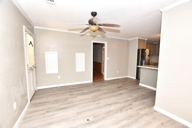 unfurnished living room featuring a textured ceiling, light wood-type flooring, ceiling fan, and ornamental molding