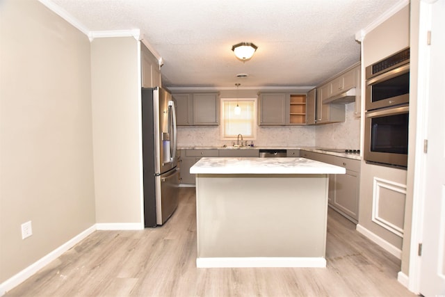 kitchen with pendant lighting, a textured ceiling, stainless steel appliances, and a kitchen island