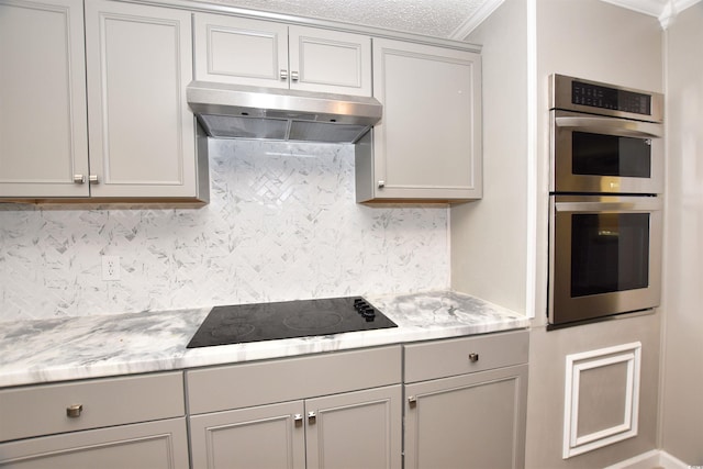 kitchen featuring crown molding, decorative backsplash, gray cabinets, black electric cooktop, and double oven