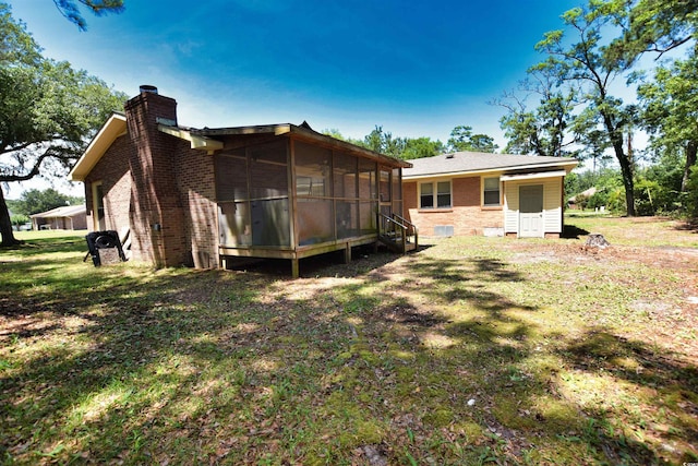 rear view of house with a yard and a sunroom