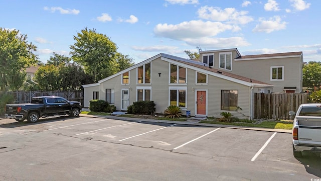 view of front of house featuring uncovered parking and fence